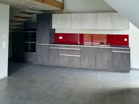 Küche mit Holztreppe und rotem Akzent